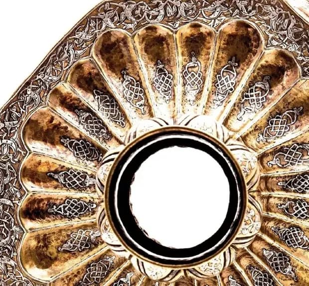 Detail of silver and gold inlay on a fluted candlestick base