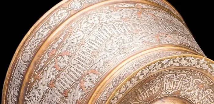 Inlaid Arabic inscription band around a candlestick body